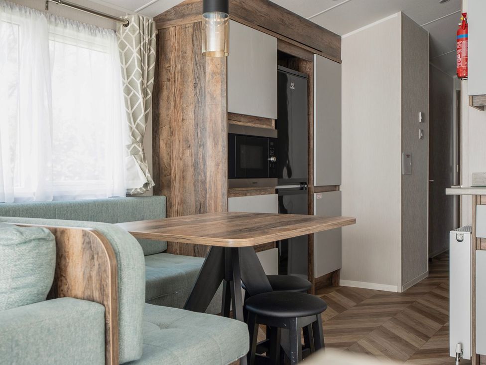A kitchen with a table and chairs at Blue Flag Shores - Hayling Island