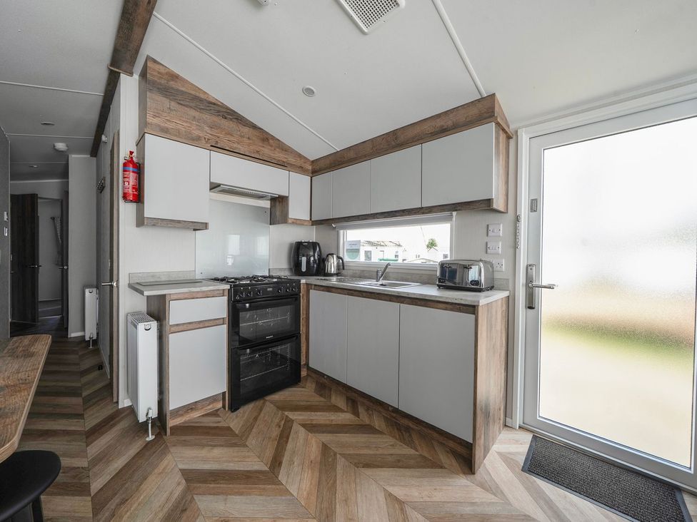A kitchen with an oven, sink, and cabinets at Blue Flag Shores - Hayling Island