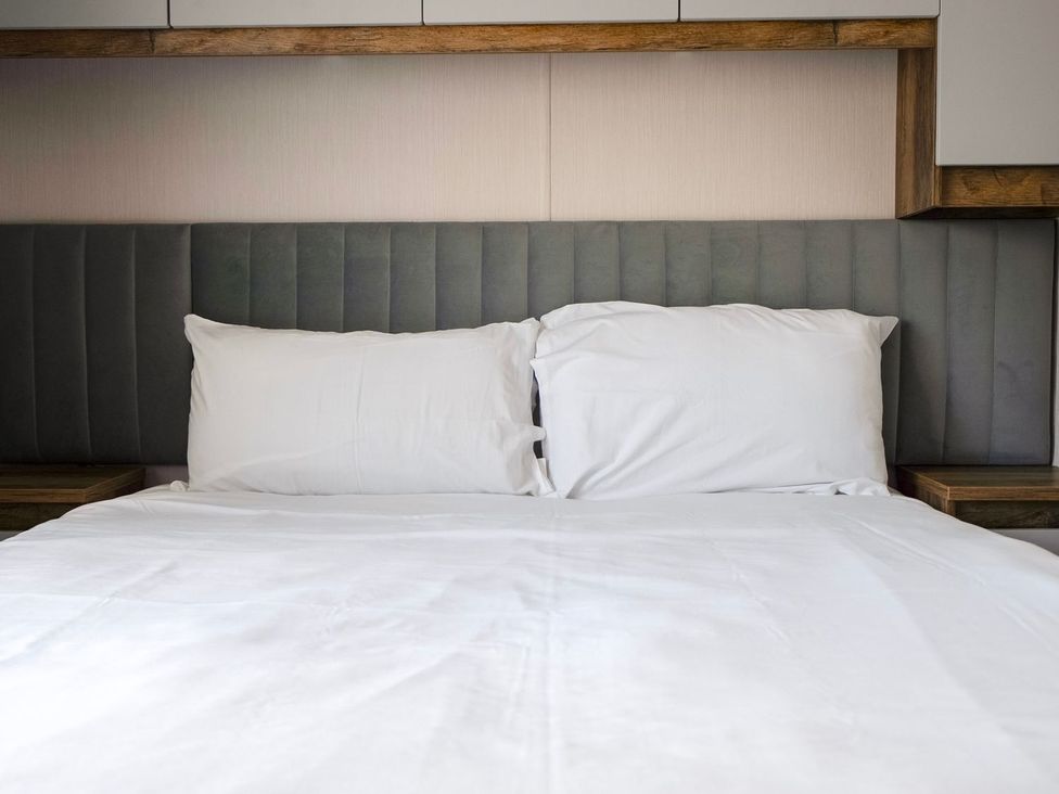 A bed with pillows and a headboard at Blue Flag Shores - Hayling Island