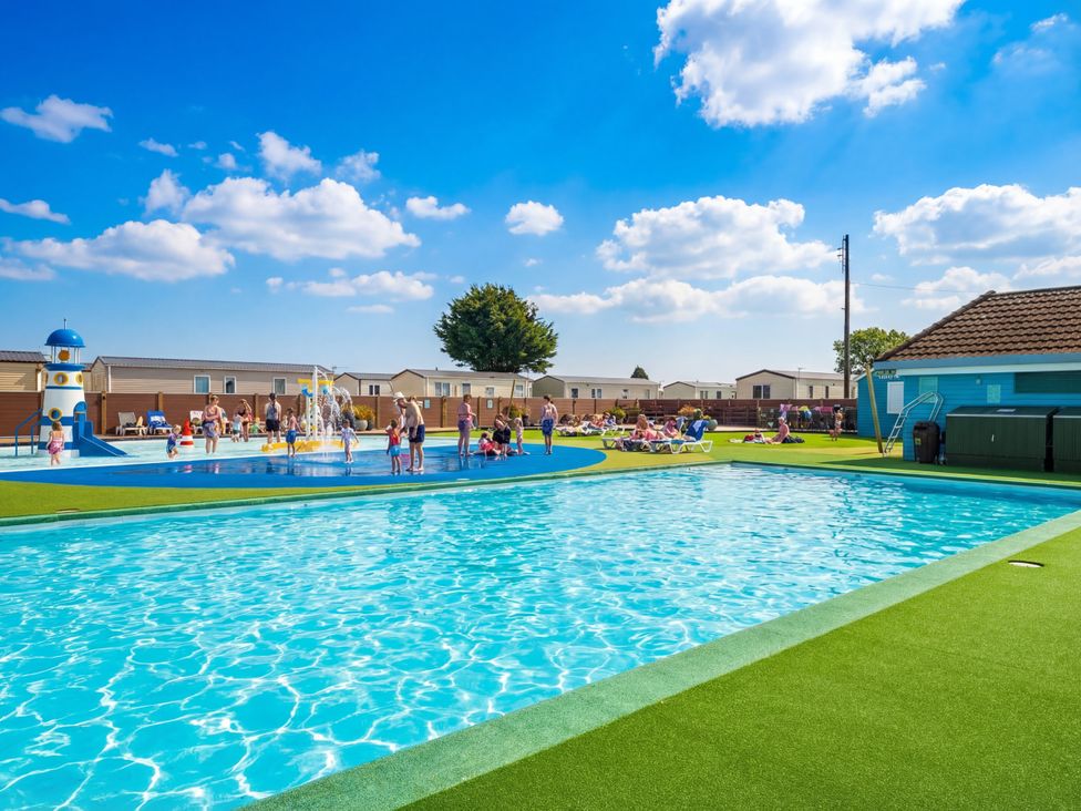 An outdoor pool area with children playing and a fountain at Blue Flag Shores - Hayling Island