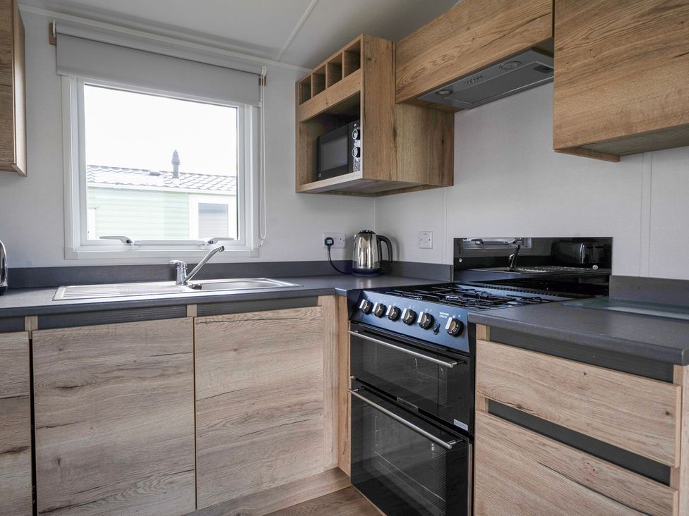 A kitchen with a sink and stove at The Splash Pad - Billing Aquadrome