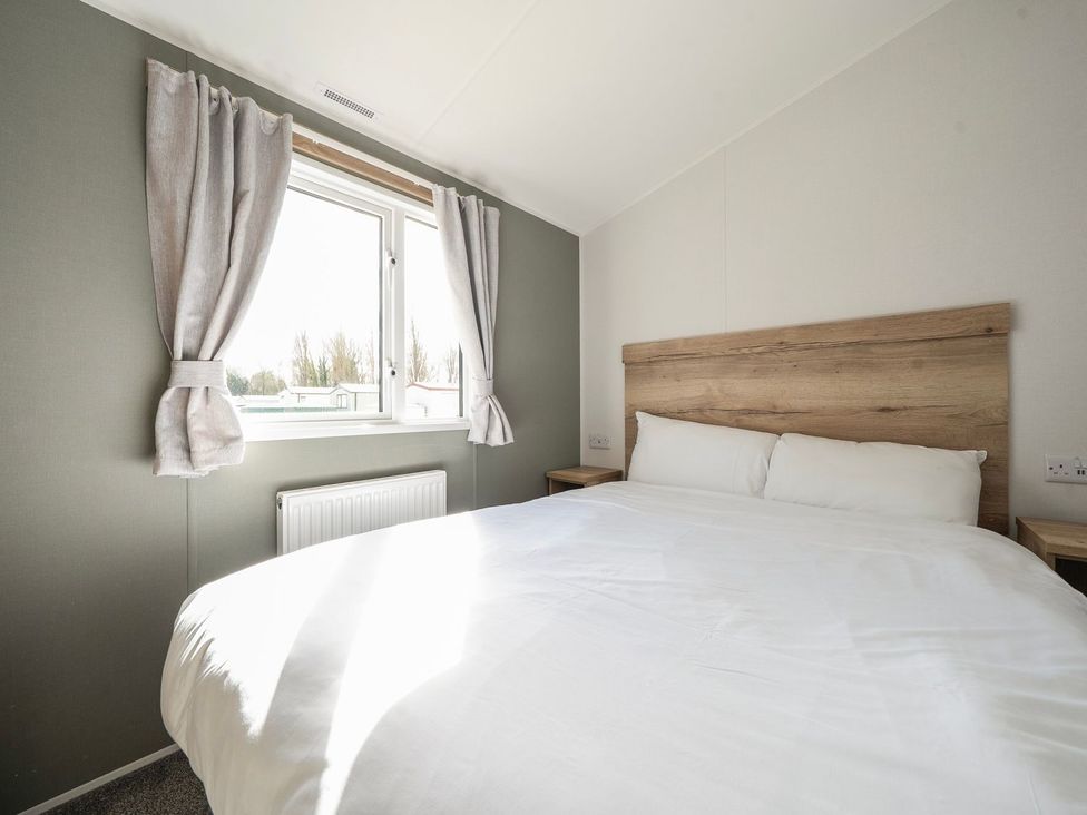 A bedroom with a double bed and a window at The Splash Pad - Billing Aquadrome