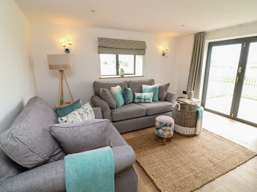 A living room with sofas and a window at Buzzard Barn in Woodhall Spa