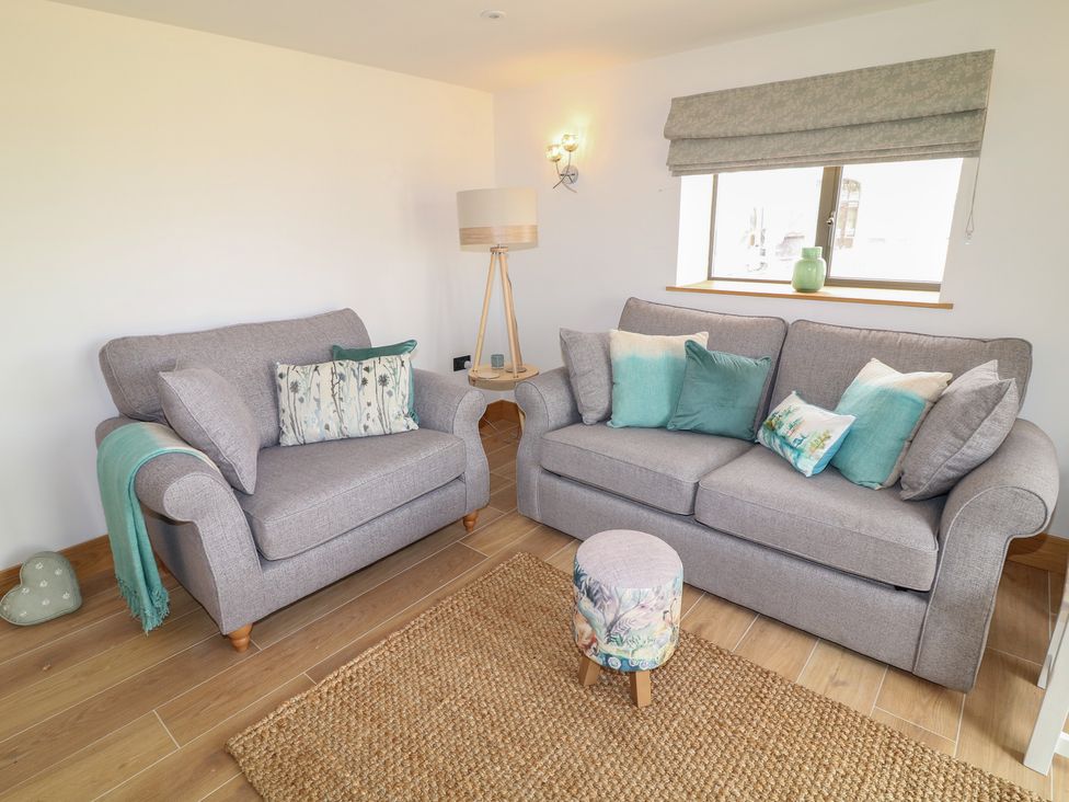 A living room with sofas and a lamp at Buzzard Barn in Woodhall Spa