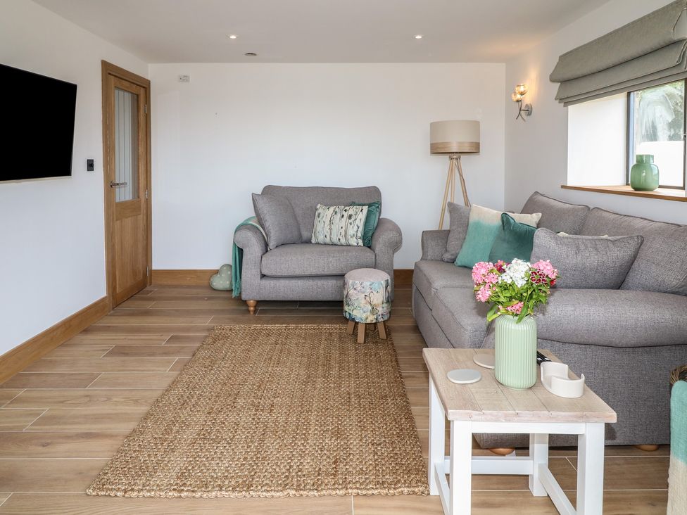 A living room with a sofa and armchair at Buzzard Barn in Woodhall Spa
