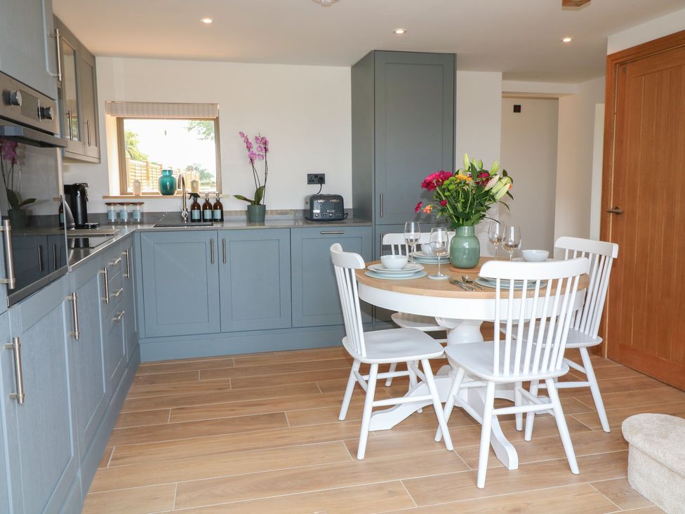 A kitchen with a table and chairs at Buzzard Barn in Woodhall Spa