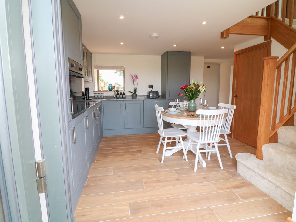 A kitchen with a dining table and chairs at Buzzard Barn Woodhall Spa