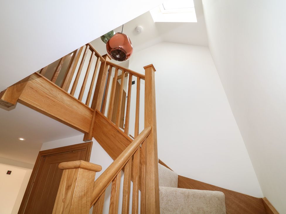 A staircase with wooden railings and a skylight at Buzzard Barn in Woodhall Spa