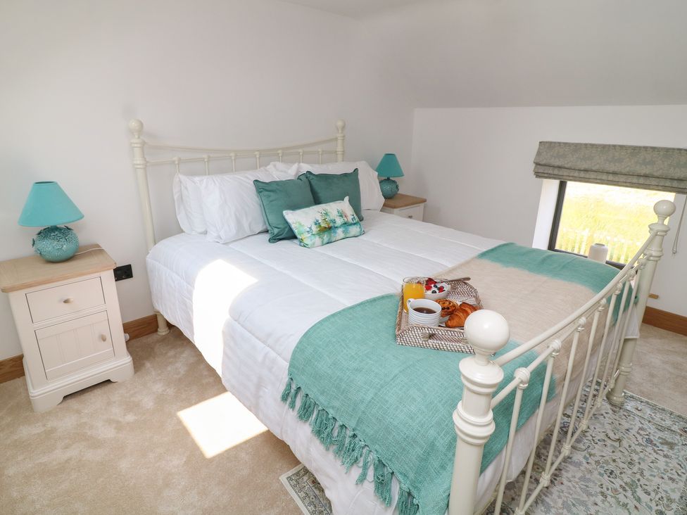 A bedroom with a bed and bedside table at Buzzard Barn Woodhall Spa
