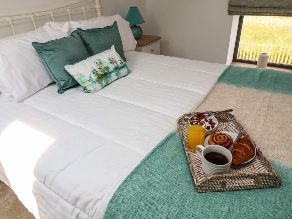 A bedroom with a bed and breakfast tray at Buzzard Barn in Woodhall Spa