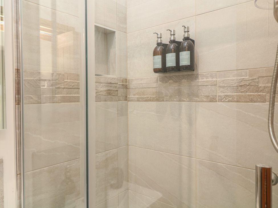 A shower with soap dispensers on the wall at Buzzard Barn in Woodhall Spa