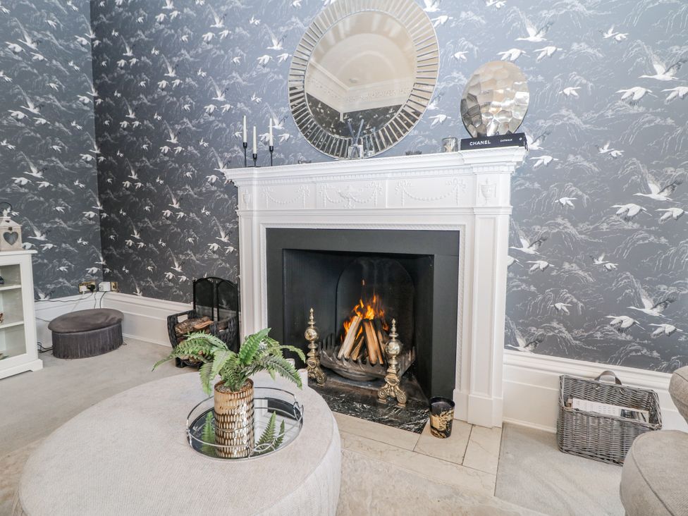 A living room with a fireplace and a mirror at Hallfield Hall in Shirland near Higham