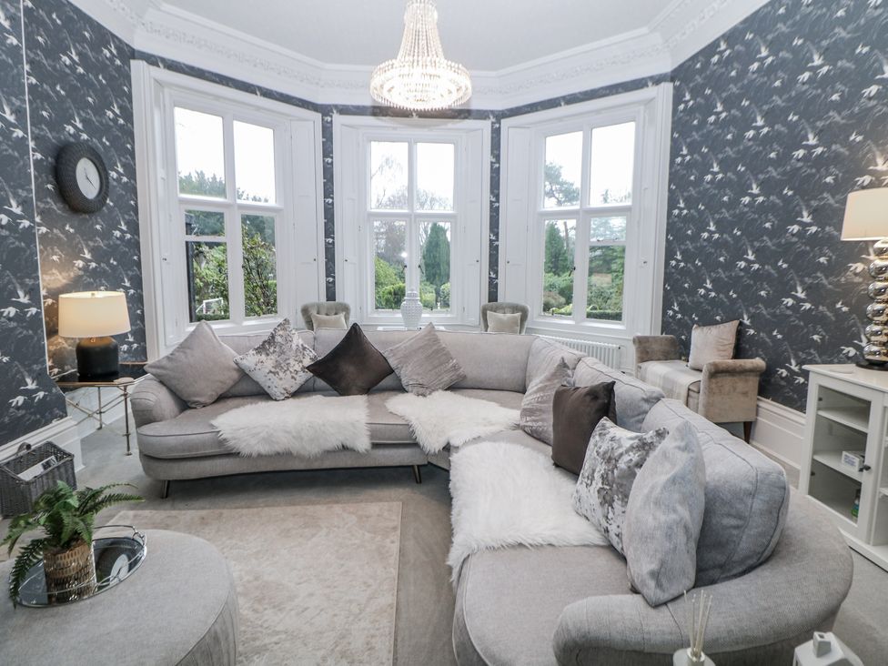 A living room with a sofa and chandelier at Hallfield Hall in Shirland near Higham