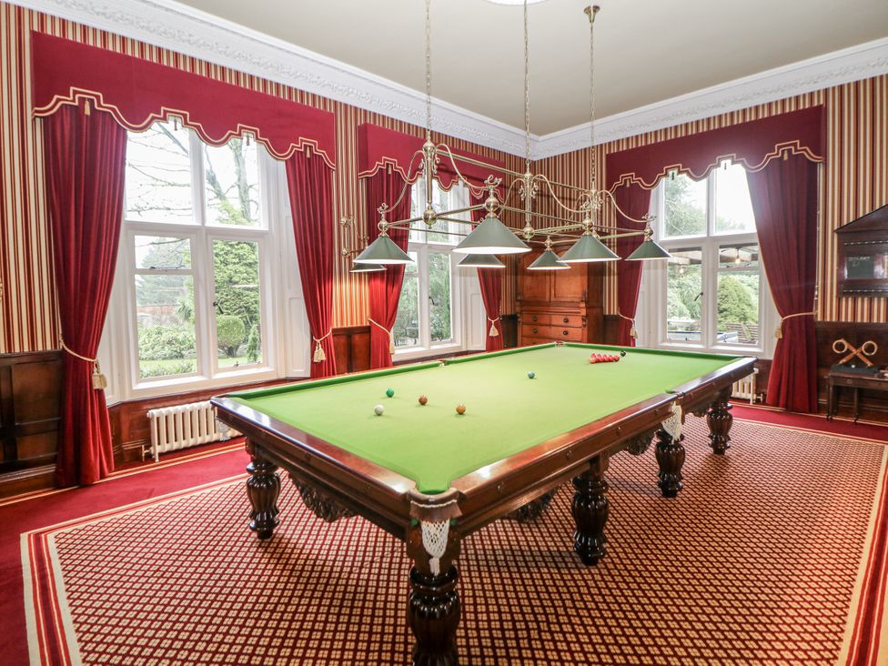 A game room with a snooker table and large windows at Hallfield Hall in Shirland near Higham
