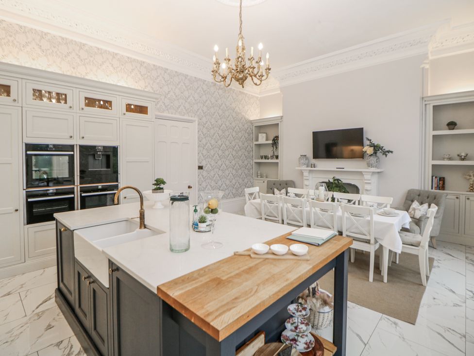 A kitchen with an island and dining area at Hallfield Hall Shirland near Higham