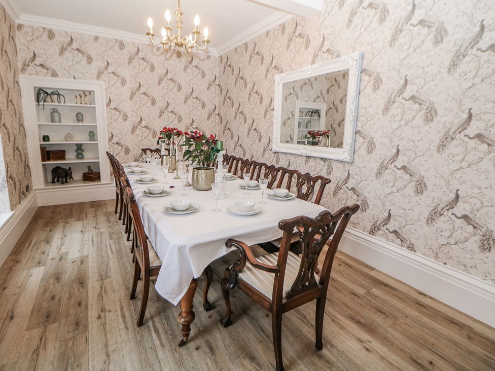 A dining room with a long table and chairs at Hallfield Hall in Shirland near Higham