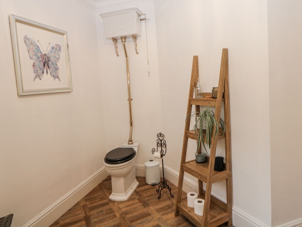 A bathroom with a toilet and ladder shelf at Hallfield Hall, Shirland near Higham