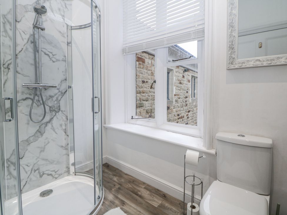 A bathroom with a shower, toilet and window at Hallfield Hall Shirland near Higham