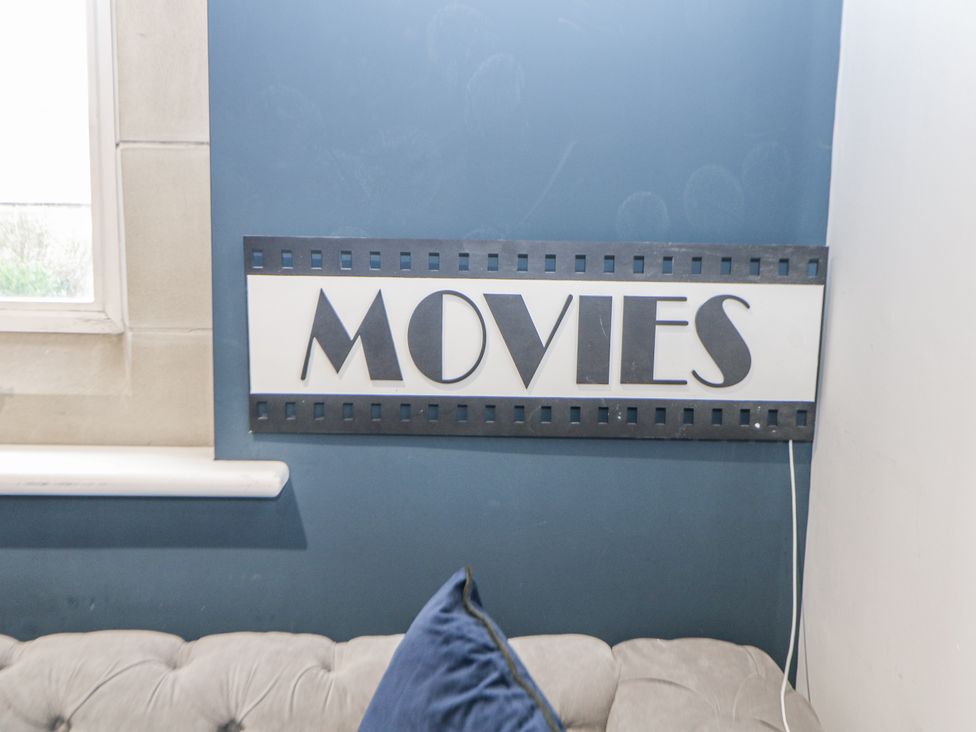 A sign that says movies on a wall in the living room at Hallfield Hall in Shirland near Higham