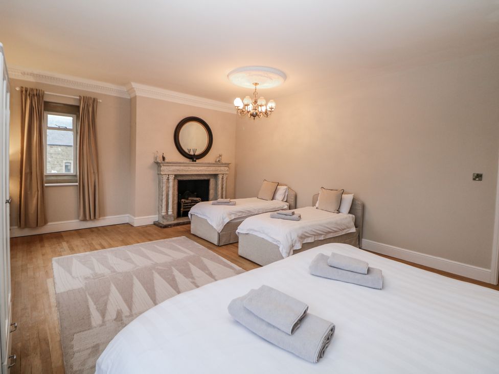 A bedroom with two beds and a fireplace at Hallfield Hall in Shirland near Higham