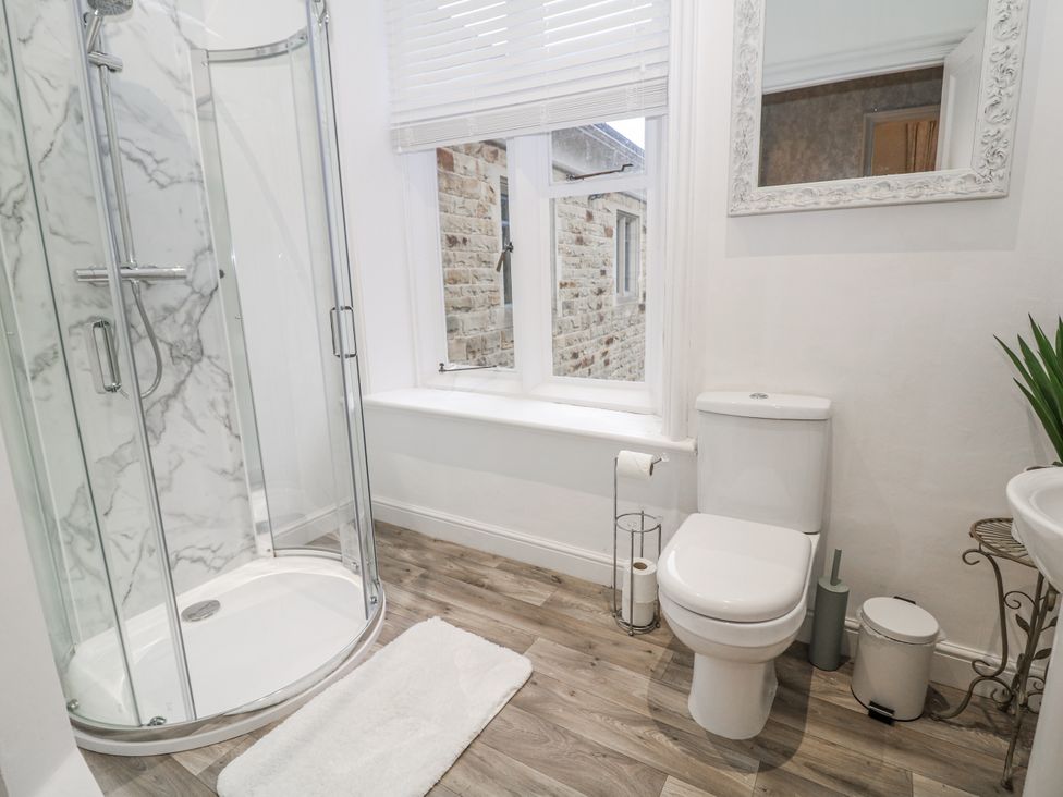 A bathroom with a shower, toilet, and wash basin at Hallfield Hall Shirland near Higham