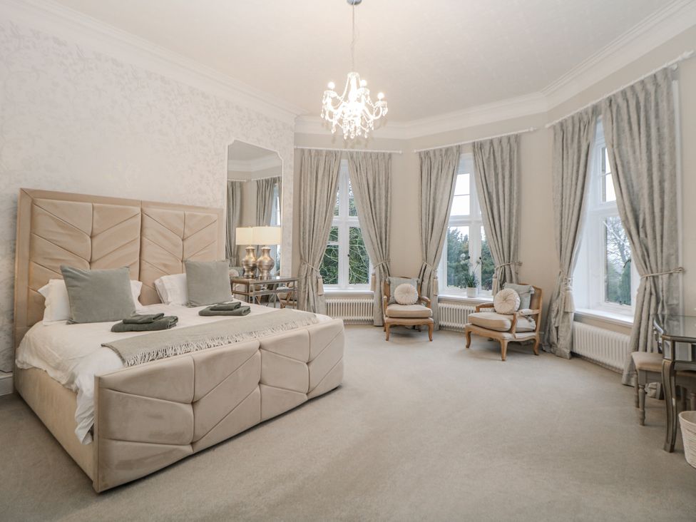 A bedroom with a bed and two chairs at Hallfield Hall in Shirland near Higham