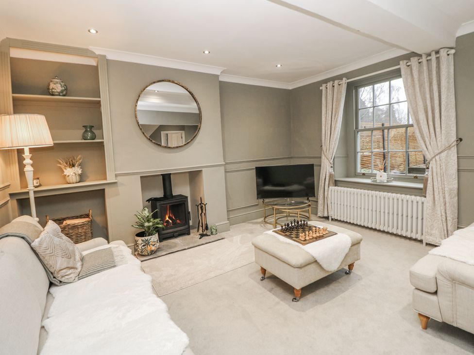 A living room with a fireplace and chessboard at Hallfield Hall Cottage in Shirland
