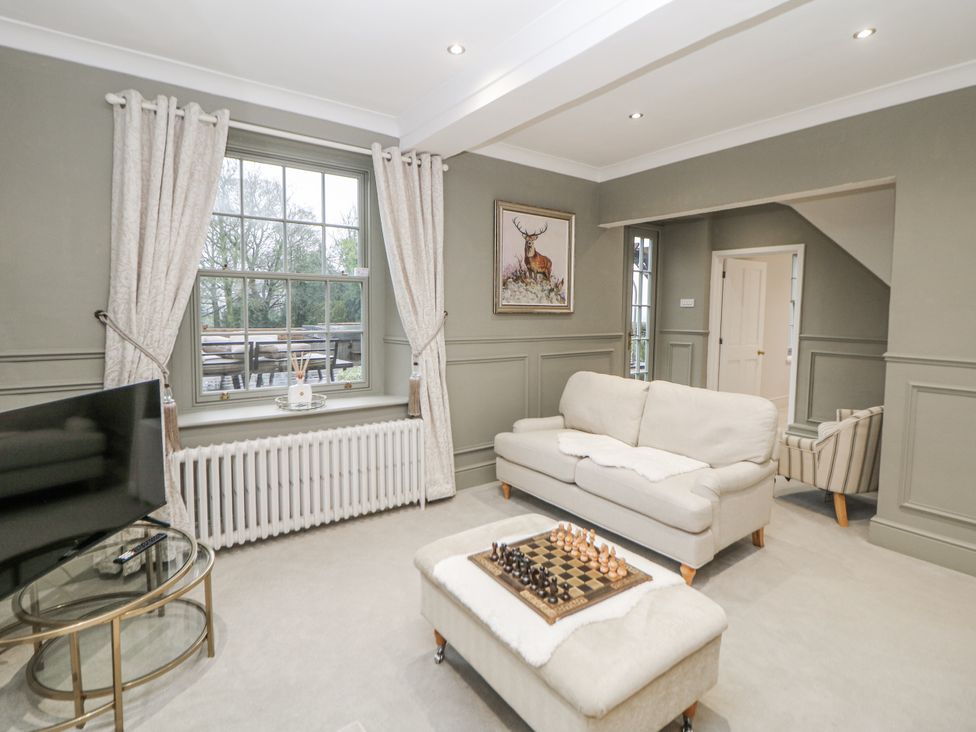 A living room with a chess set on a table at Hallfield Hall Cottage in Shirland