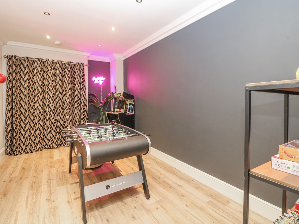 A game room with a foosball table and arcade machine at Hallfield Hall Cottage, Shirland