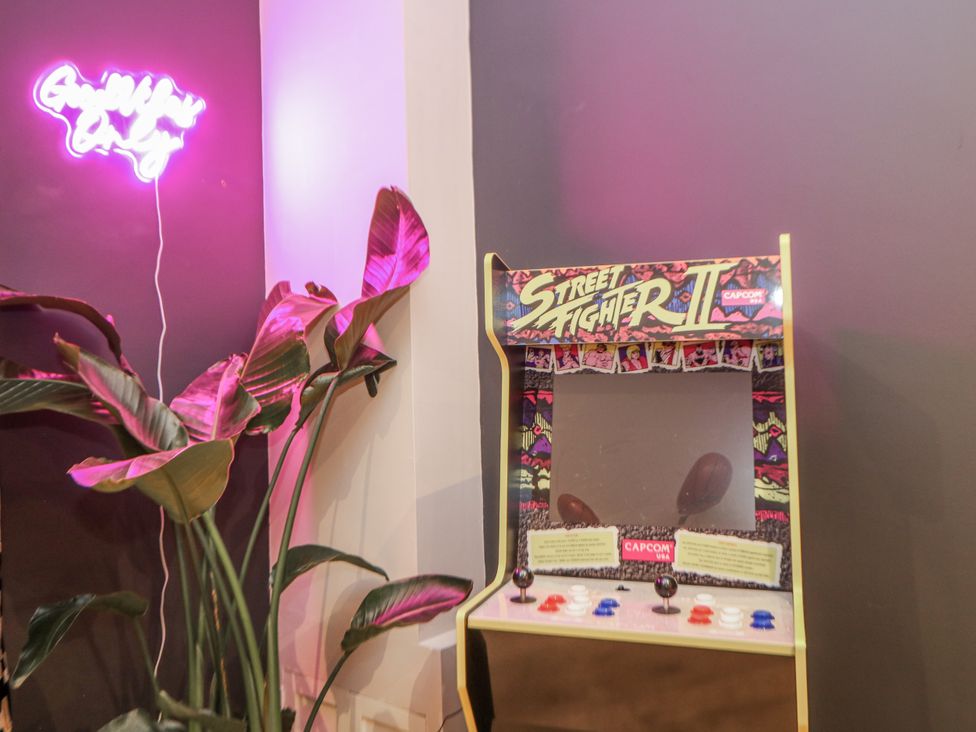 An arcade cabinet for Street Fighter II with a neon light at Hallfield Hall Cottage in Shirland