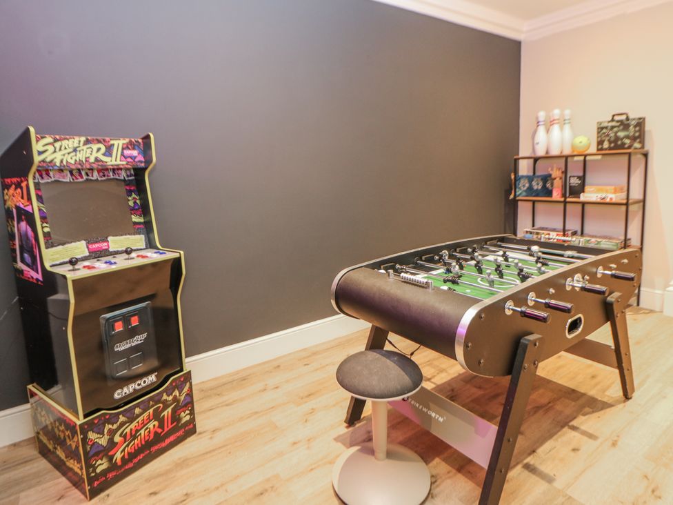 A game room with an arcade machine and a foosball table at Hallfield Hall Cottage in Shirland