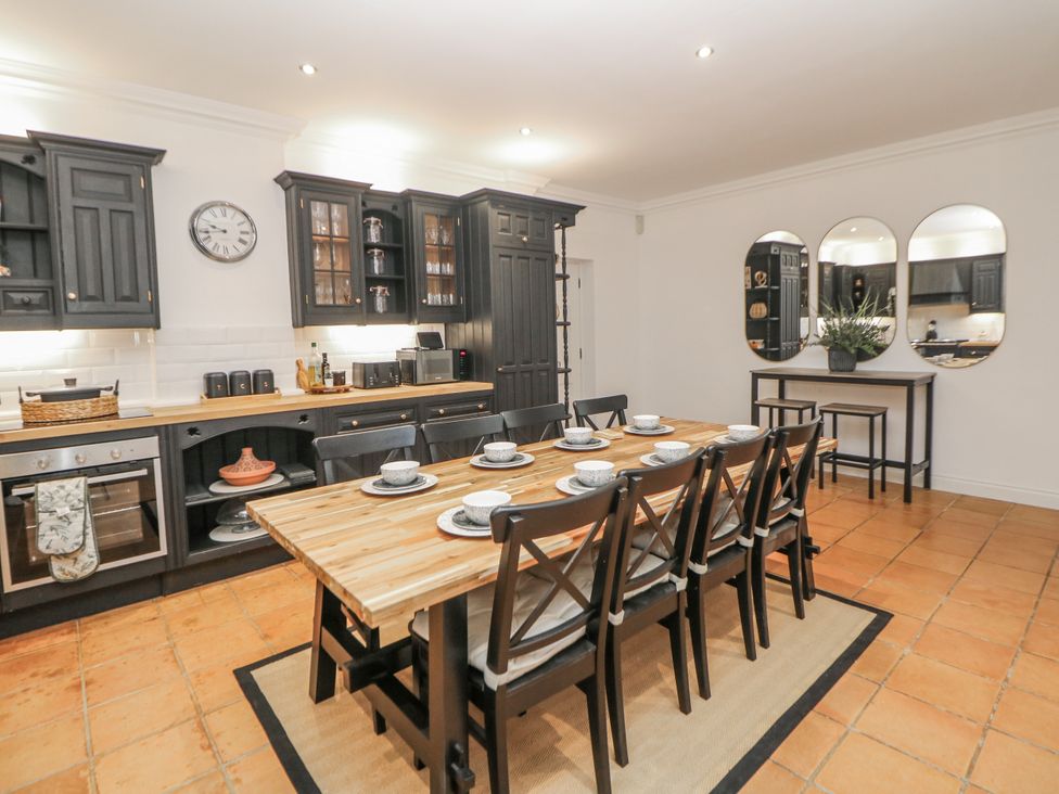 A kitchen with a dining table and chairs at Hallfield Hall Cottage in Shirland