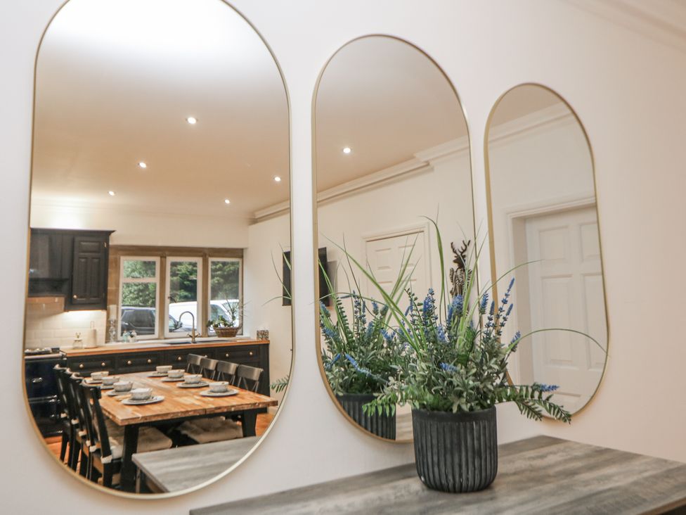 A dining room with mirrors and a table at Hallfield Hall Cottage in Shirland