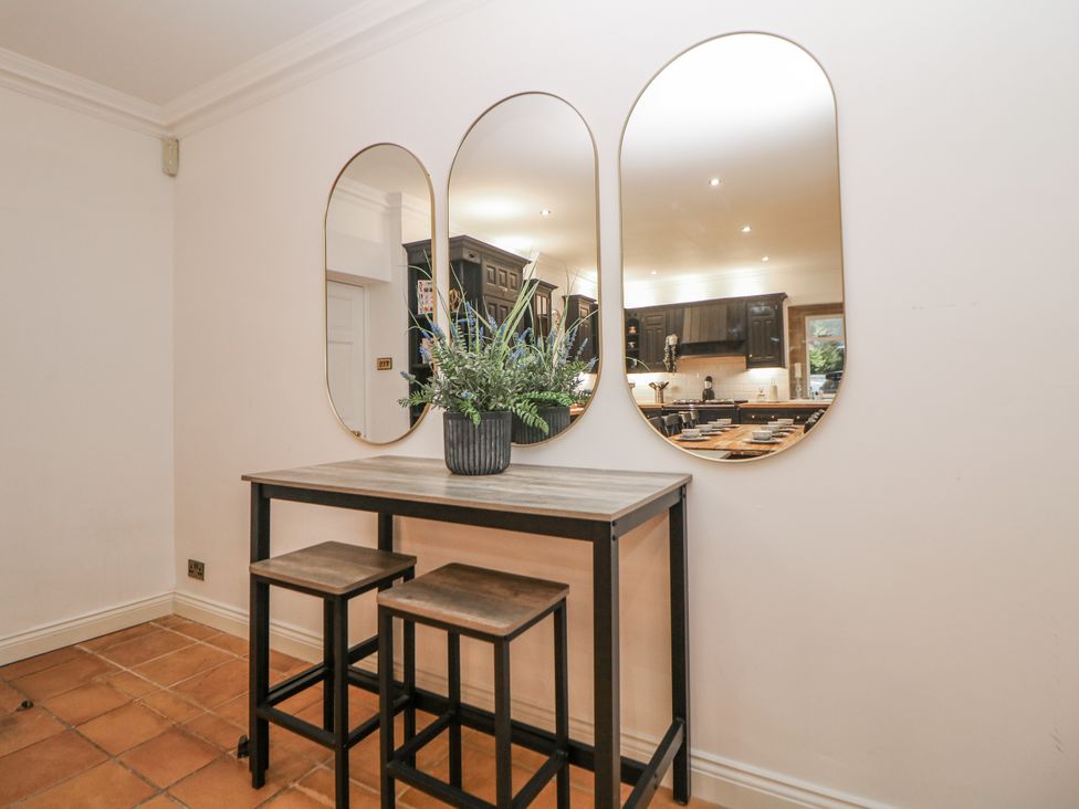 A table with stools and mirrors at Hallfield Hall Cottage in Shirland