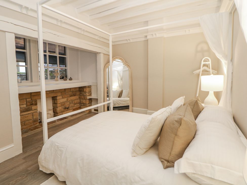 A bedroom with a bed and decorative pillows at Hallfield Hall Cottage in Shirland