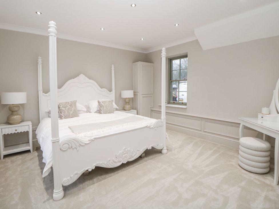 A bedroom with a four-poster bed and bedside tables at Hallfield Hall Cottage Shirland