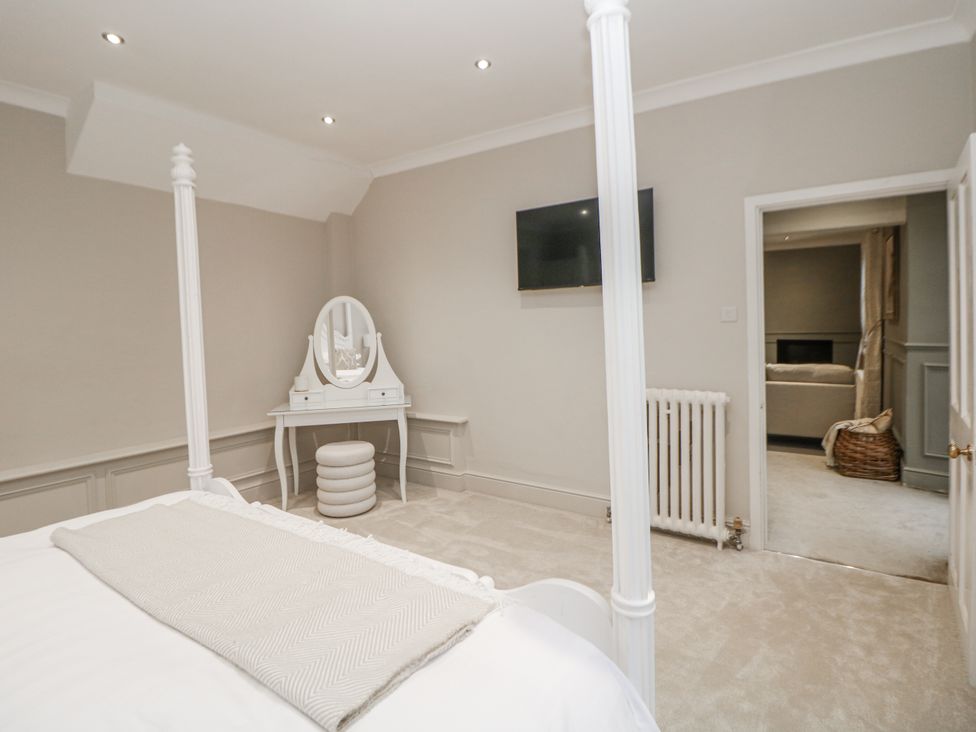 A bedroom with a bed and vanity table at Hallfield Hall Cottage in Shirland