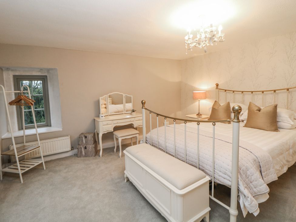 A bedroom with a bed and dressing table at Hallfield Hall Cottage in Shirland