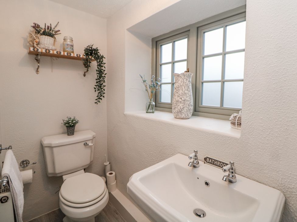 A bathroom with a toilet and sink at Hallfield Hall Cottage Shirland