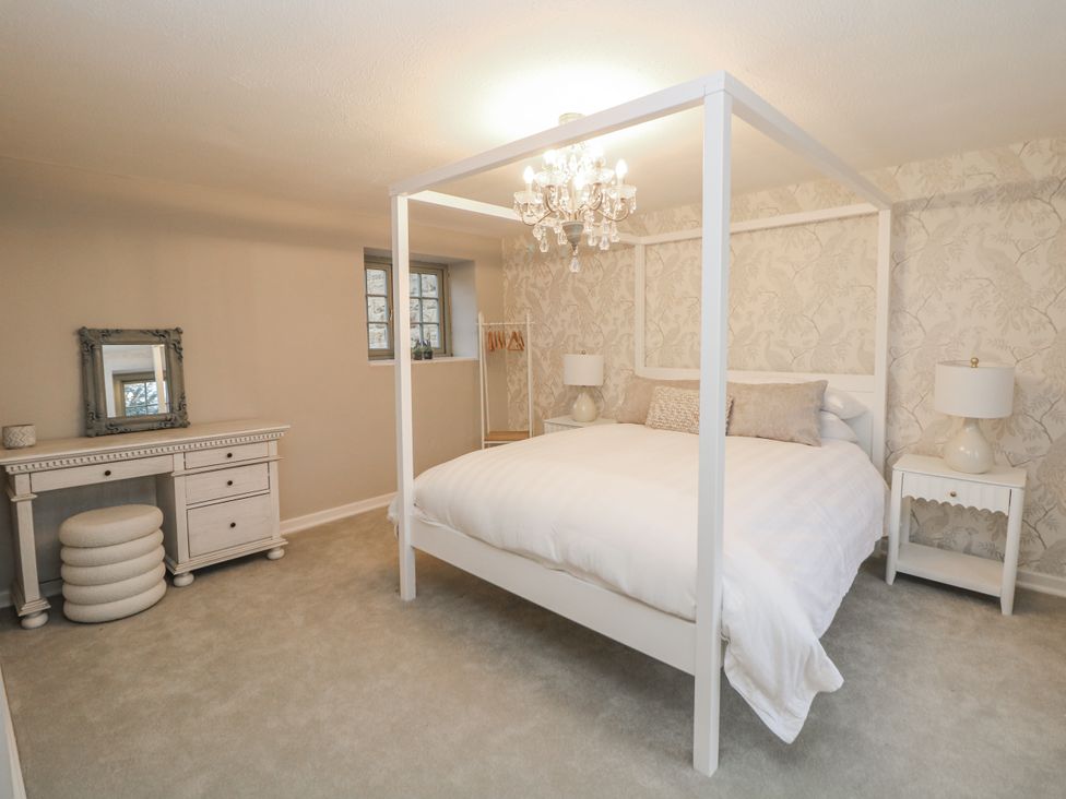 A bedroom with a four-poster bed and a dresser at Hallfield Hall Cottage in Shirland
