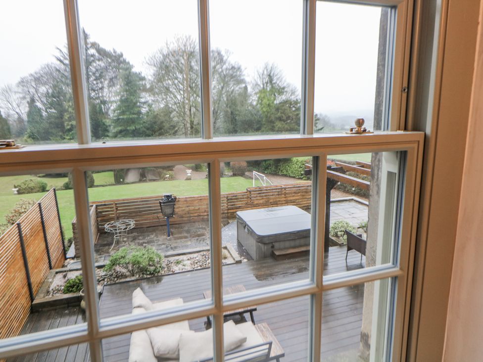 A garden view with a hot tub and furniture at Hallfield Hall Cottage Shirland