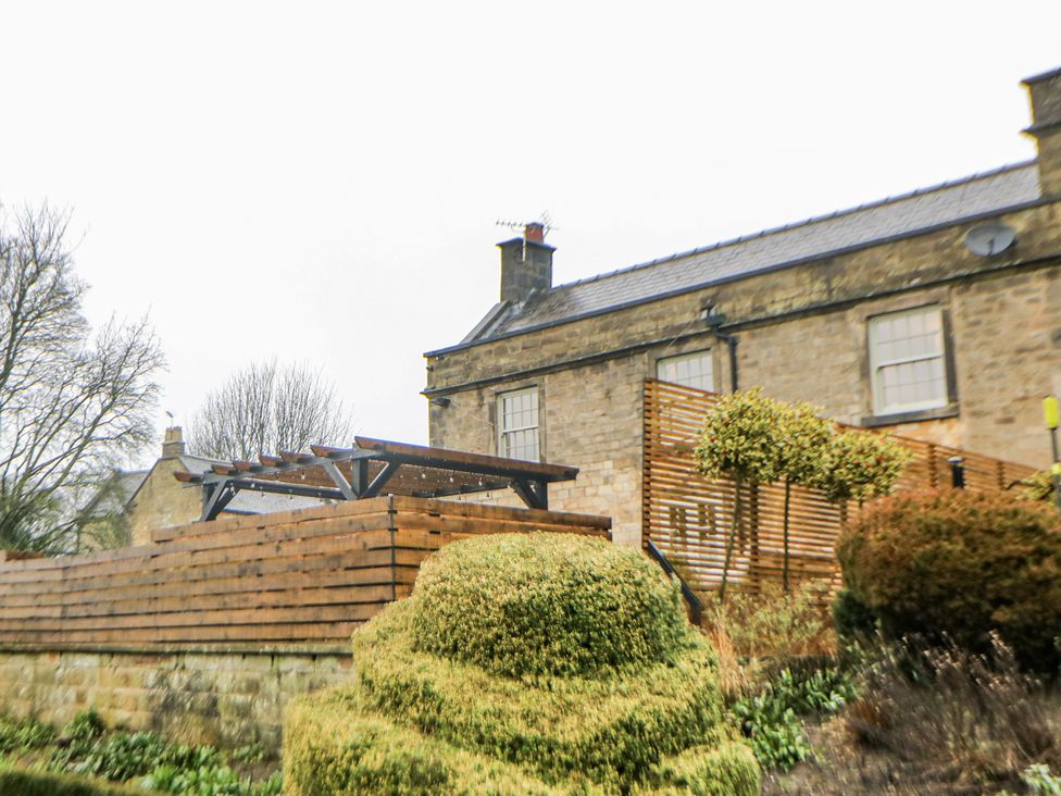 An outdoor view of a building with a garden at Hallfield Hall Cottage in Shirland