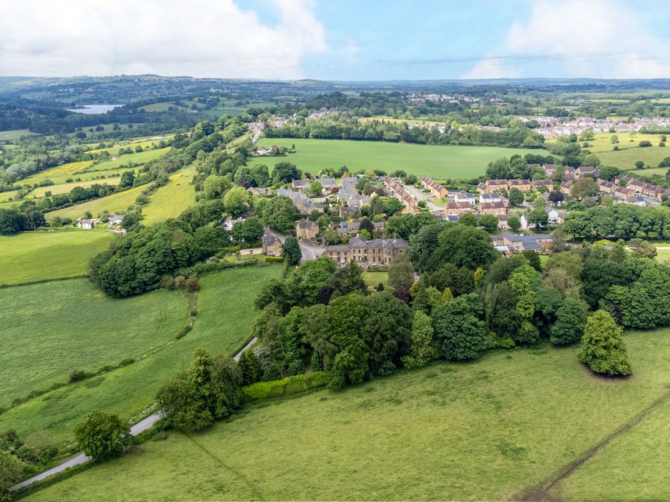 Aerial view of a village with fields and trees at Hallfield Hall Cottage in Shirland