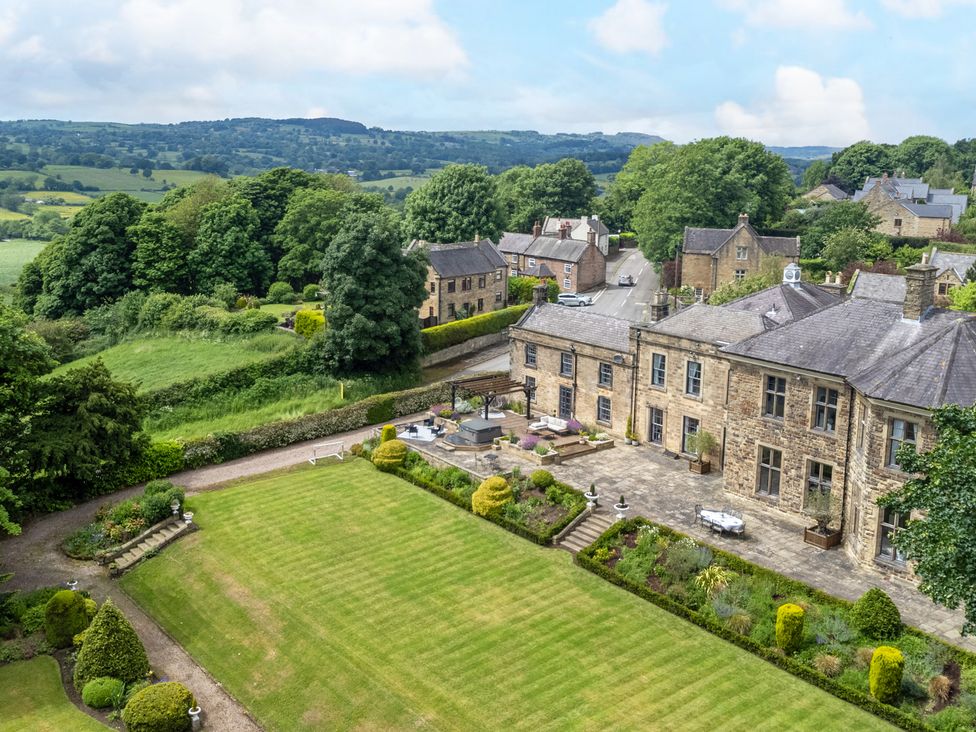 An outdoor view of a garden and house at Hallfield Hall Cottage in Shirland