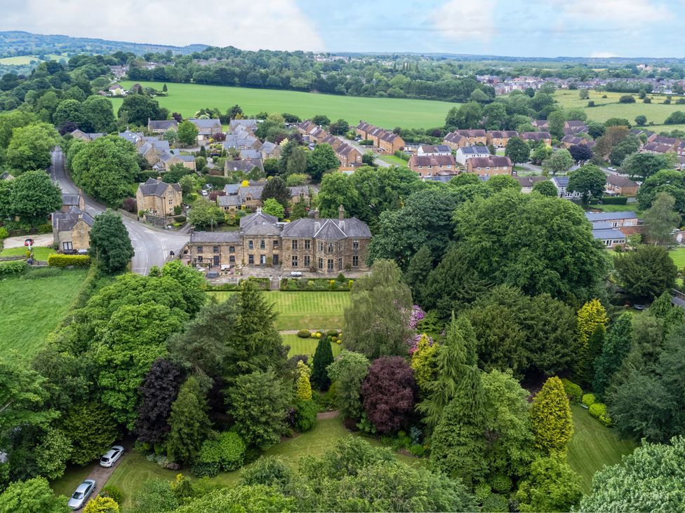 An aerial view of a residential area with trees and houses at Hallfield Hall Cottage in Shirland