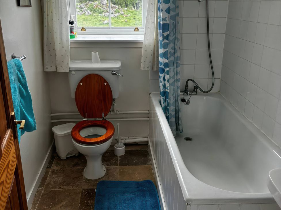 A bathroom with a bathtub and toilet at Strathnoon in Clune near Carrbridge