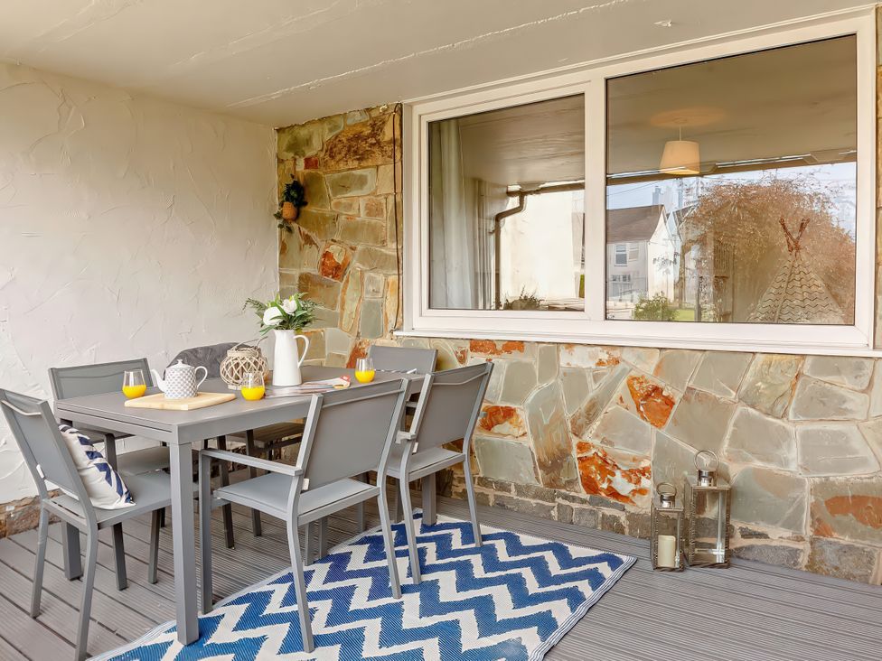 A dining area with a table and chairs at Ty Golau in Llanbedrog