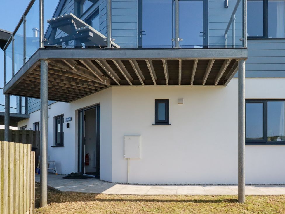An outdoor area with a balcony, door and windows at Jacana in Perranporth