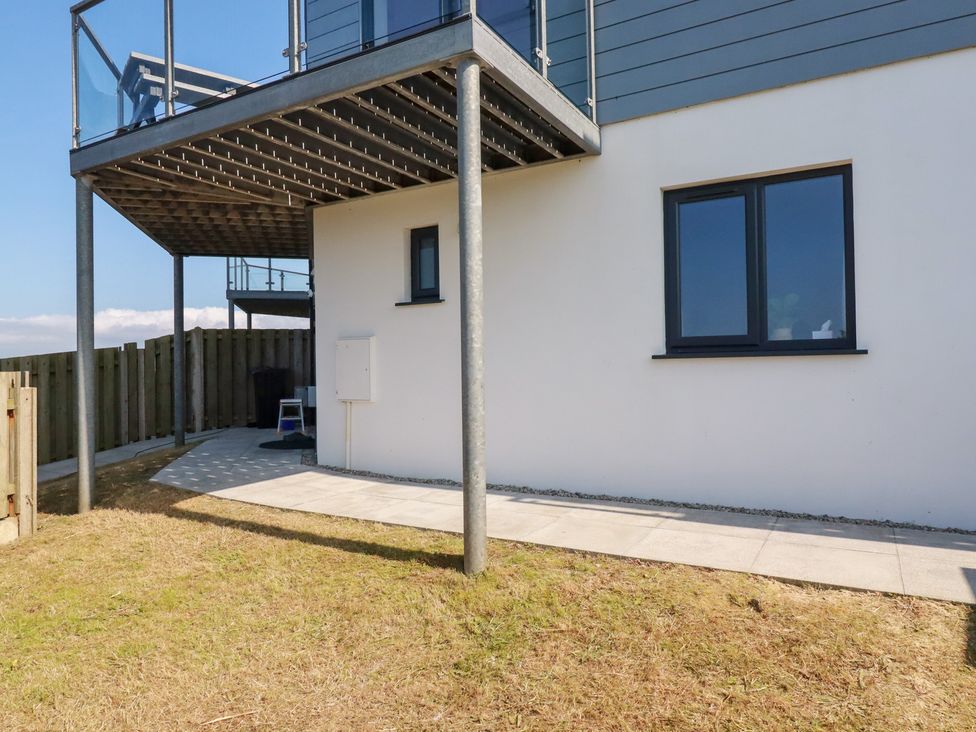 An outdoor area with a building, patio, and grass at Jacana in Perranporth