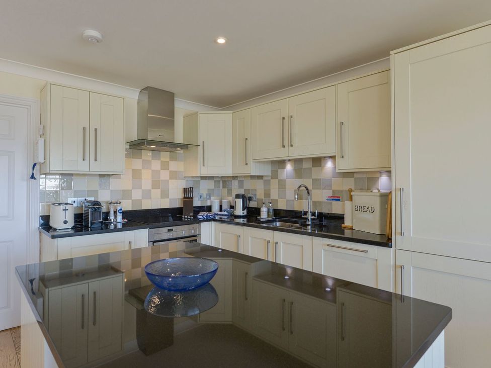 A kitchen featuring cabinets, sink, stove, toaster, and kettle at Apartment 12, Burgh Island Causeway, Bigbury-On-Sea